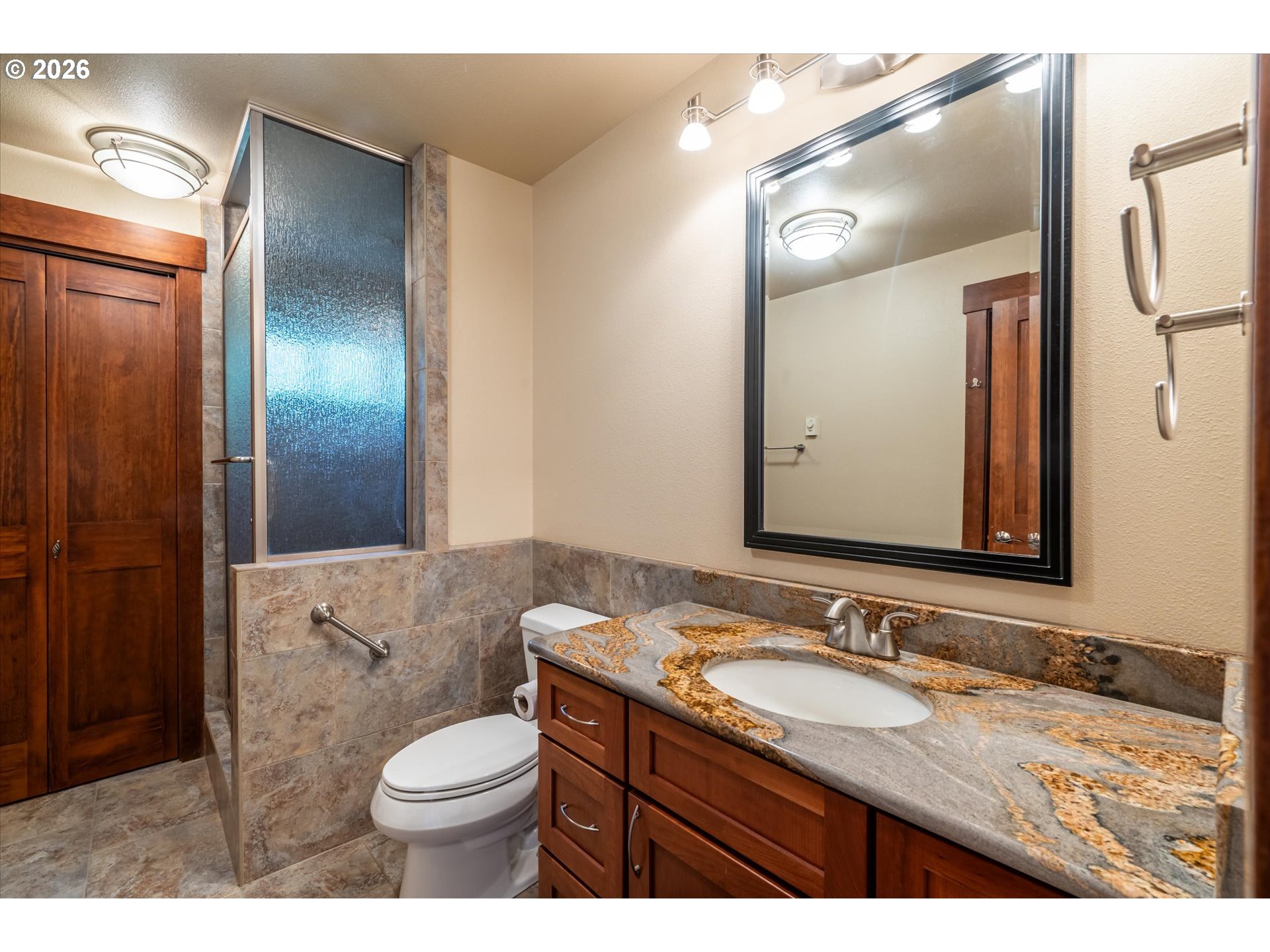 650 Tichenor Cemetery Road Port Orford, OR 97465 - Photo 28 of 48 a bathroom with a granite countertop sink toilet a mirror and shower