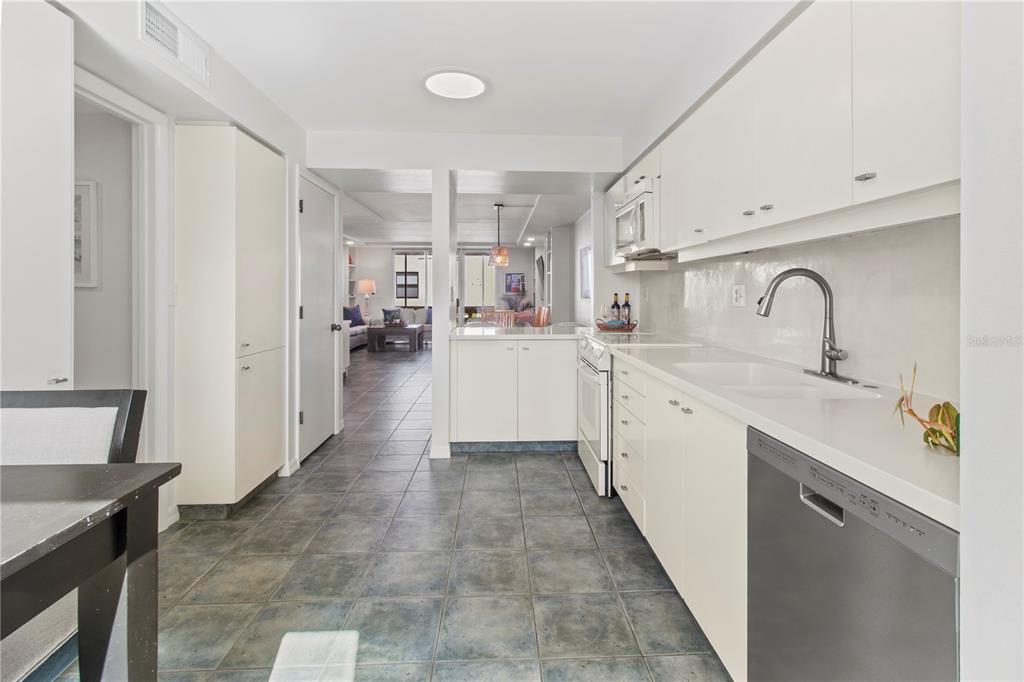 829 Bayport Way, Unit 829 Longboat Key, FL 34228 - Photo 11 of 58 a large white kitchen with a sink a counter space and stainless steel appliances