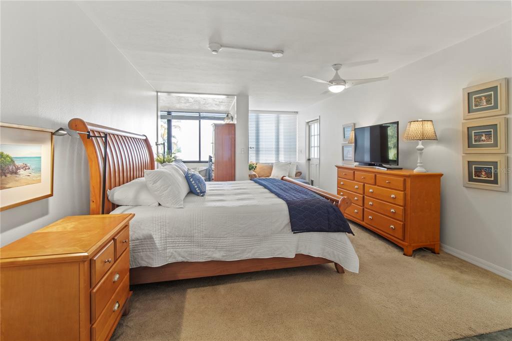 829 Bayport Way, Unit 829 Longboat Key, FL 34228 - Photo 20 of 58 a bedroom with a bed and a flat tv screen on dresser