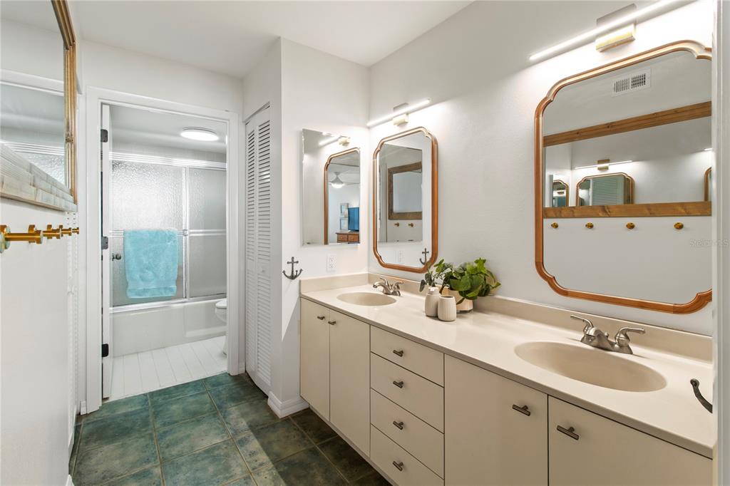 829 Bayport Way, Unit 829 Longboat Key, FL 34228 - Photo 24 of 58 a bathroom with a double vanity sink mirror and bathtub