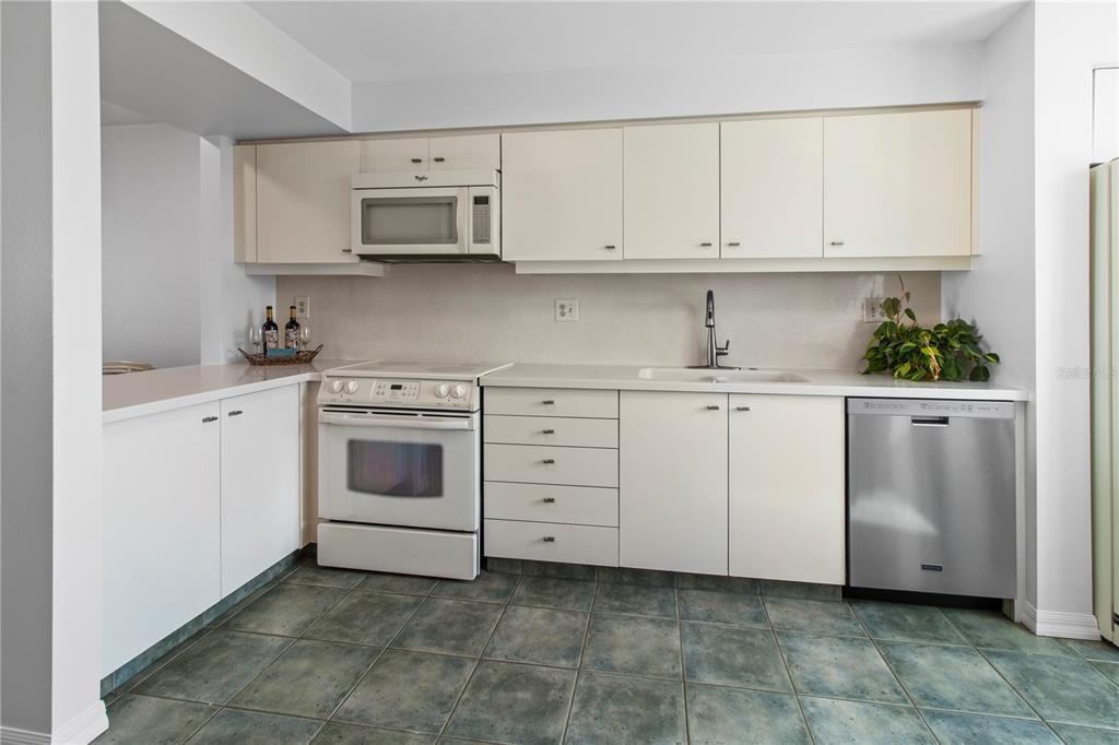 829 Bayport Way, Unit 829 Longboat Key, FL 34228 - Photo 9 of 58 a kitchen with white cabinets and white appliances