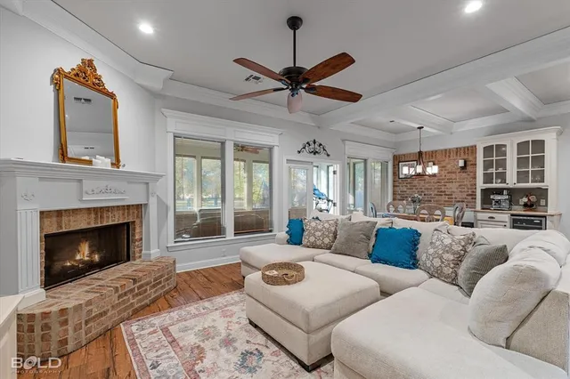 a living room with furniture a fireplace and a ceiling fan