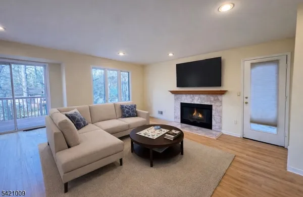 a living room with furniture a flat screen tv and a fireplace