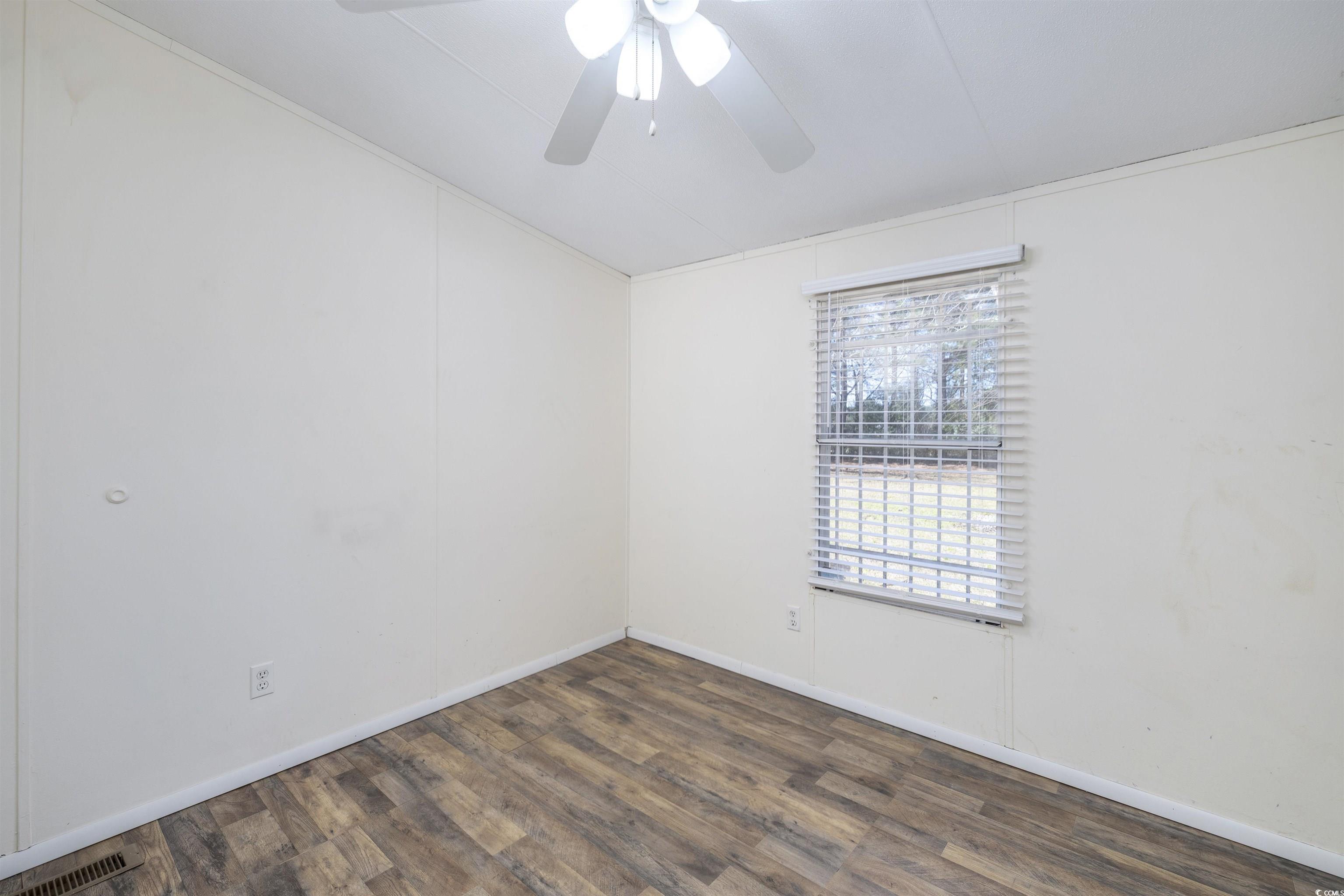 5764 Thompson Road Nichols, SC 29581 - Photo 11 of 35 Empty room featuring a ceiling fan, wood finished floors, visible vents, and baseboards