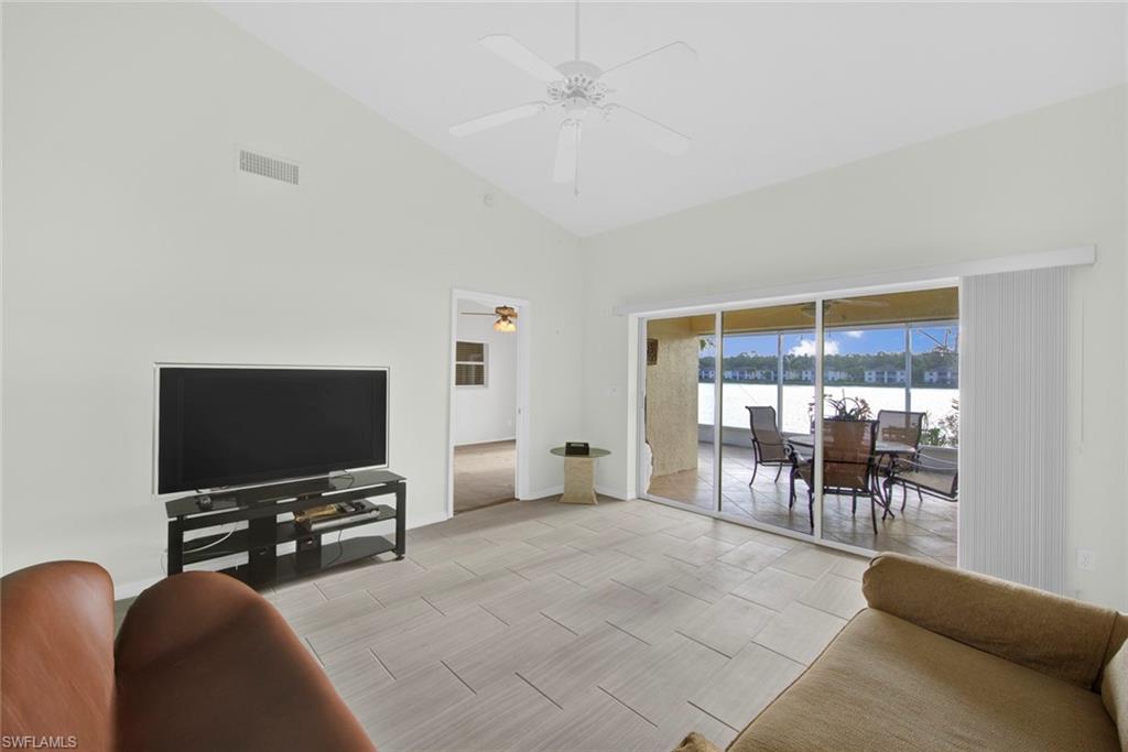 2912 West Crown Pointe Boulevard, Unit 141 Naples, FL 34112 - Photo 12 of 32 a living room with furniture and a flat screen tv