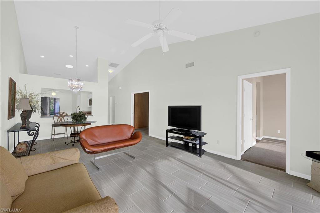 2912 West Crown Pointe Boulevard, Unit 141 Naples, FL 34112 - Photo 13 of 32 a living room with furniture and a flat screen tv