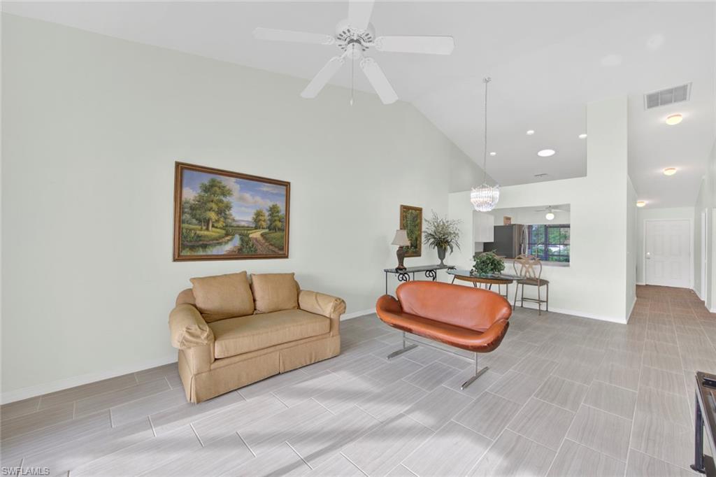 2912 West Crown Pointe Boulevard, Unit 141 Naples, FL 34112 - Photo 14 of 32 a living room with furniture and a chandelier