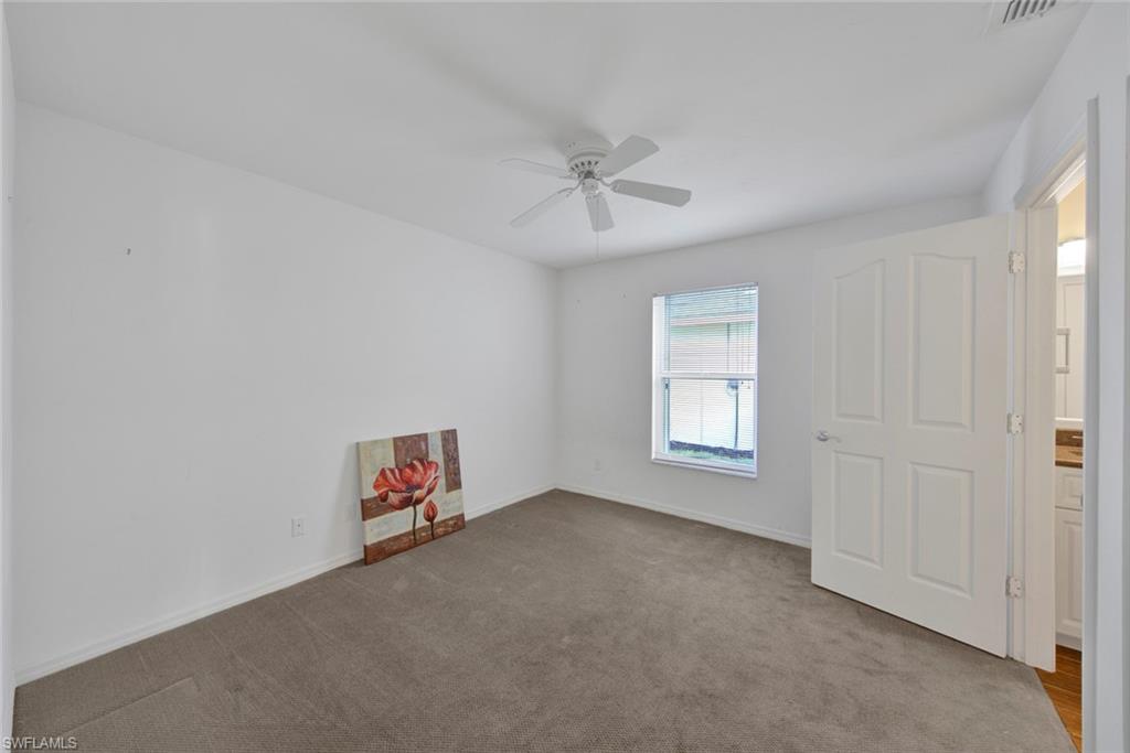 2912 West Crown Pointe Boulevard, Unit 141 Naples, FL 34112 - Photo 15 of 32 an empty room with windows and ceiling fan