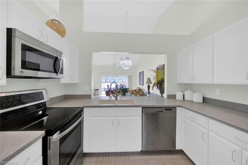 2912 West Crown Pointe Boulevard, Unit 141 Naples, FL 34112 - Photo 5 of 32 a kitchen with a sink stove and microwave