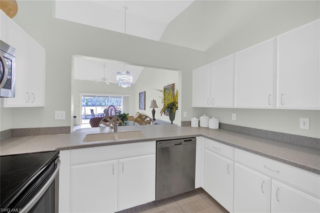 2912 West Crown Pointe Boulevard, Unit 141 Naples, FL 34112 - Photo 6 of 32 a kitchen with white cabinets and white appliances