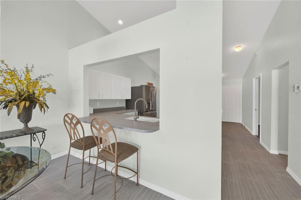2912 West Crown Pointe Boulevard, Unit 141 Naples, FL 34112 - Photo 8 of 32 a view of a dining room with furniture and wooden floor