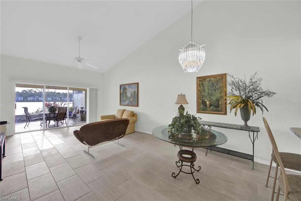 2912 West Crown Pointe Boulevard, Unit 141 Naples, FL 34112 - Photo 9 of 32 a living room with furniture and a chandelier