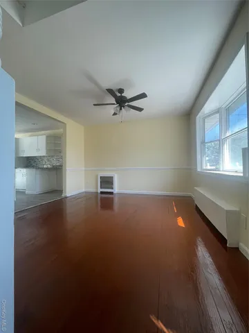 an empty room with windows and ceiling fan