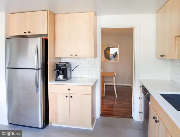 a large kitchen with kitchen island a sink a stove and white cabinets