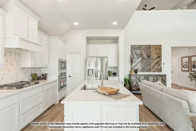 a kitchen with stainless steel appliances kitchen island granite countertop a sink a stove and white cabinets
