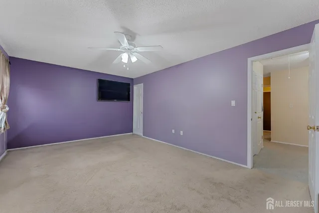 an empty room with a ceiling fan and a window