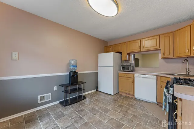 a kitchen with refrigerator a stove a sink and a refrigerator