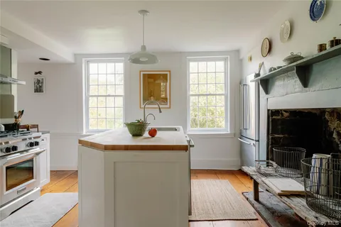 a view of a hallway with wooden floor and a dining table