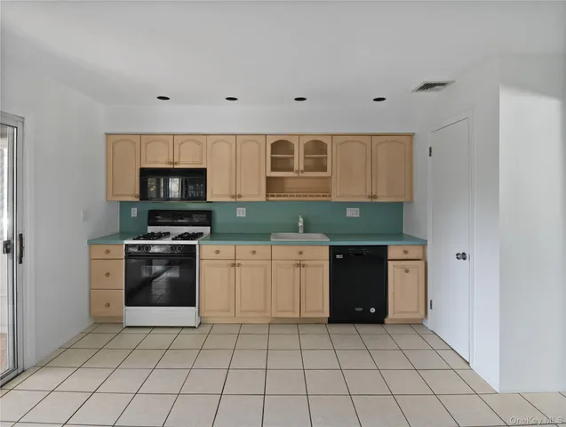 a kitchen with a sink a refrigerator and cabinets