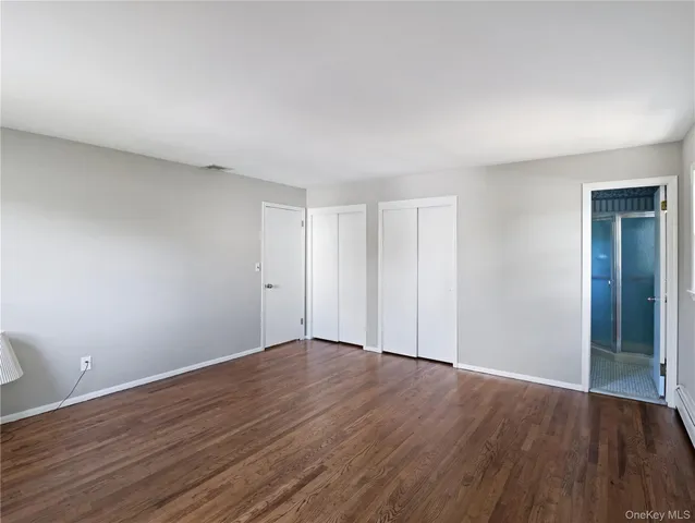 a view of a room that has wooden floor and windows in it