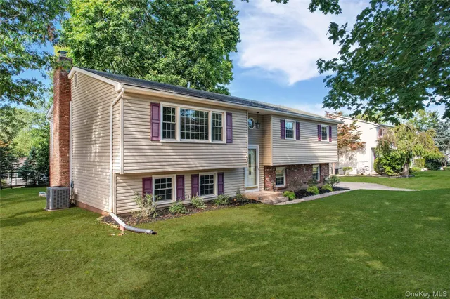 a front view of house with a garden and trees