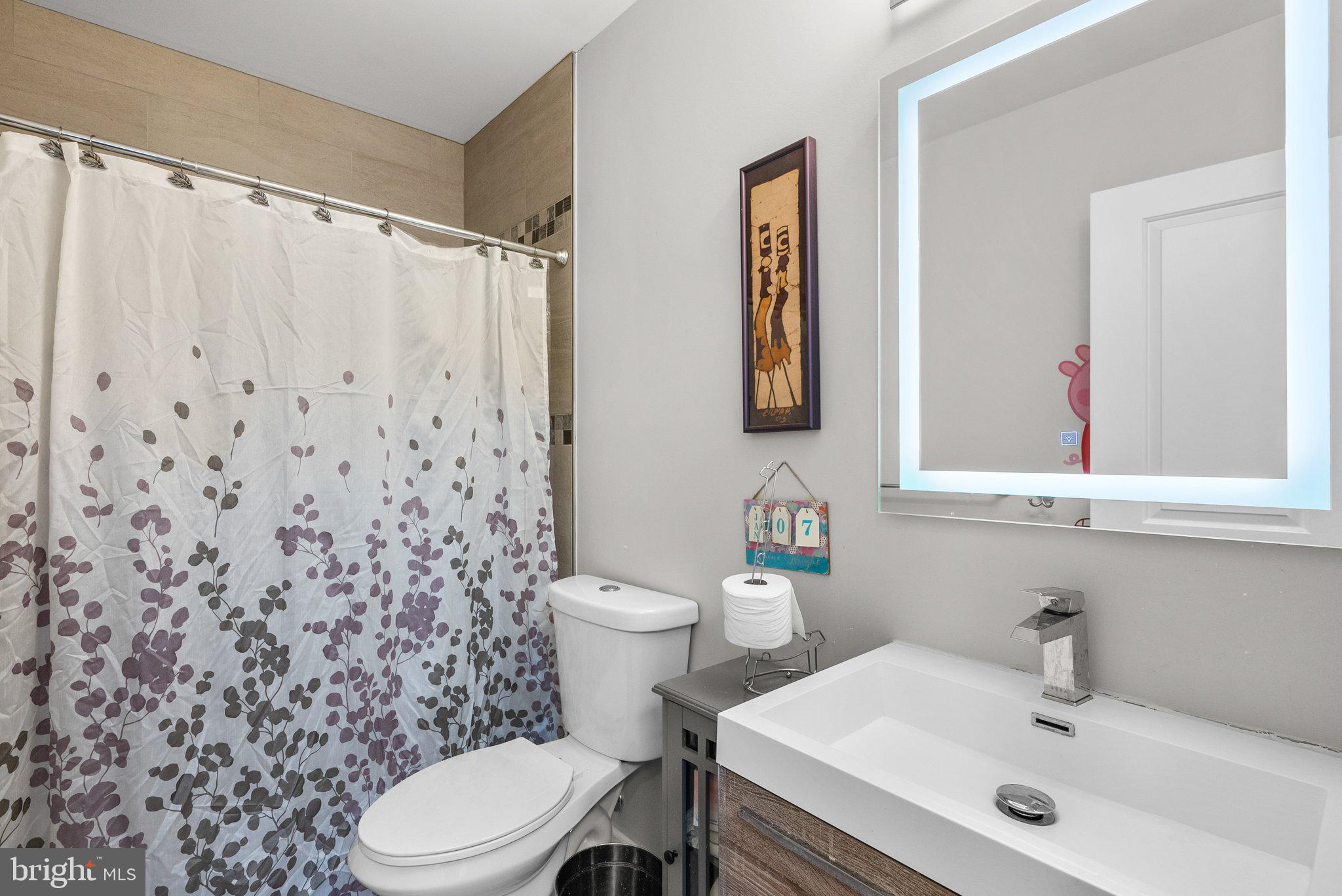 1275 Oates Street Northeast Washington, DC 20002 - Photo 22 of 40 a bathroom with a sink a toilet and a mirror