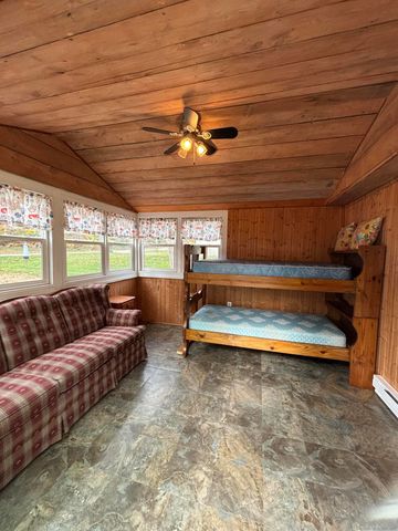 a living room with furniture a ceiling fan and a large window