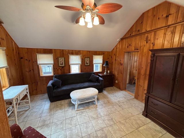 a living room with furniture a flat screen tv and a window