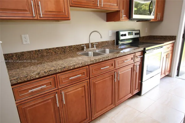 a kitchen with granite countertop white cabinets and sink
