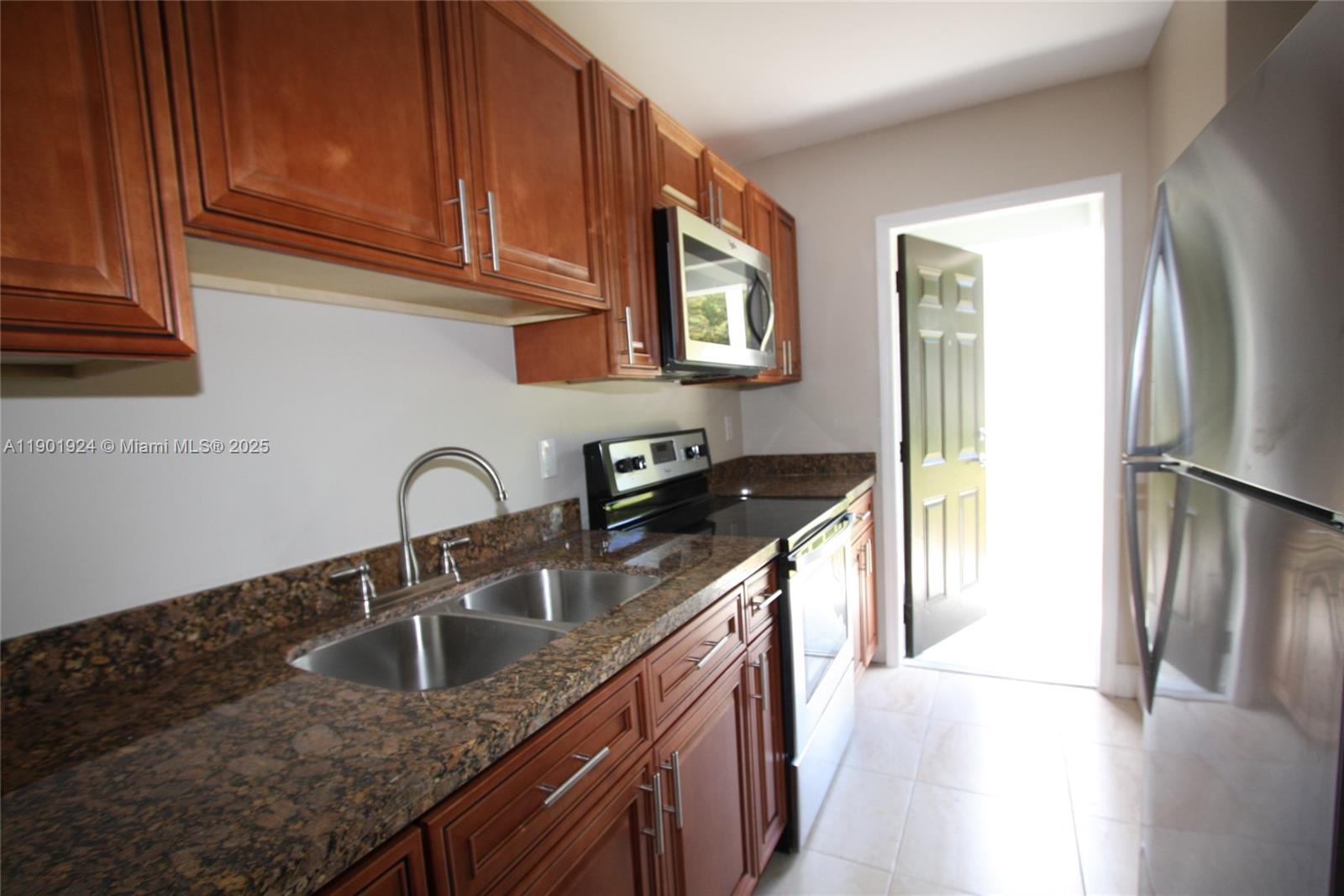 479 Northwest 19th Street, Unit 352 Miami, FL 33136 - Photo 14 of 16 a kitchen with stainless steel appliances granite countertop a sink a refrigerator and a stove