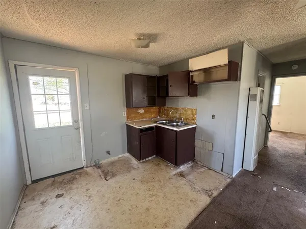 a kitchen with stainless steel appliances kitchen island granite countertop a refrigerator and a sink