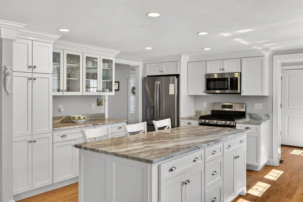 a kitchen with granite countertop a stove refrigerator and microwave