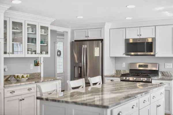 a kitchen with stainless steel appliances granite countertop a stove a sink and a microwave