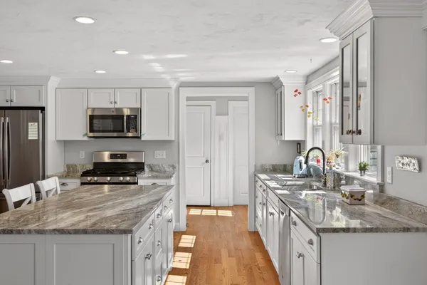 a kitchen with stainless steel appliances granite countertop a sink stove and refrigerator