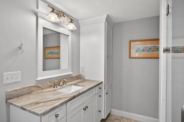 a bathroom with a granite countertop sink and a mirror