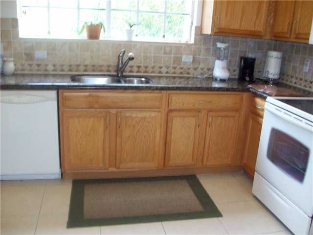 4508 Danson Way Delray Beach, FL 33445 - Photo 2 of 25 a kitchen with granite countertop a sink a stove and cabinets