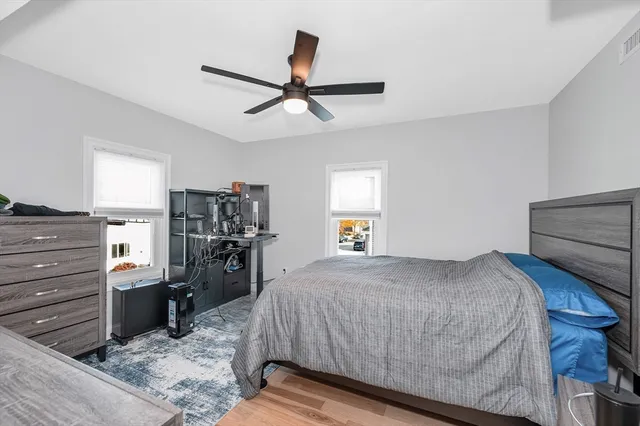 a bedroom with a bed and wooden floor