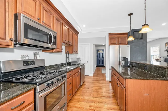 a kitchen with stainless steel appliances granite countertop a stove a sink and a microwave