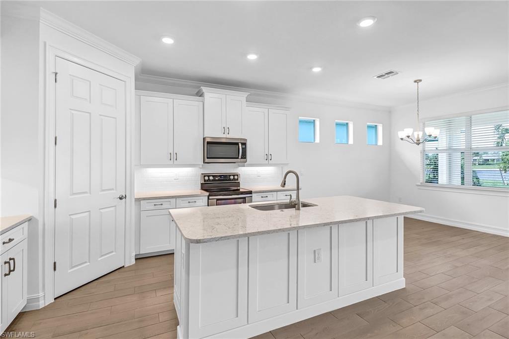 317 Spiaggio Court Naples, FL 34114 - Photo 1 of 46 a kitchen with appliances a sink and cabinets
