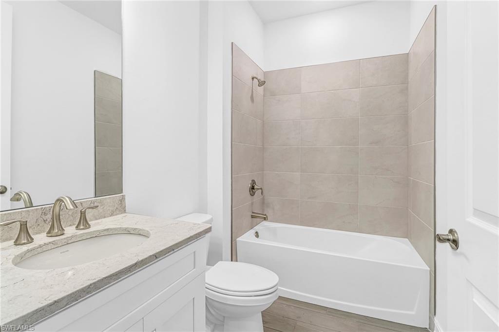 317 Spiaggio Court Naples, FL 34114 - Photo 11 of 46 a bathroom with a granite countertop sink toilet and shower