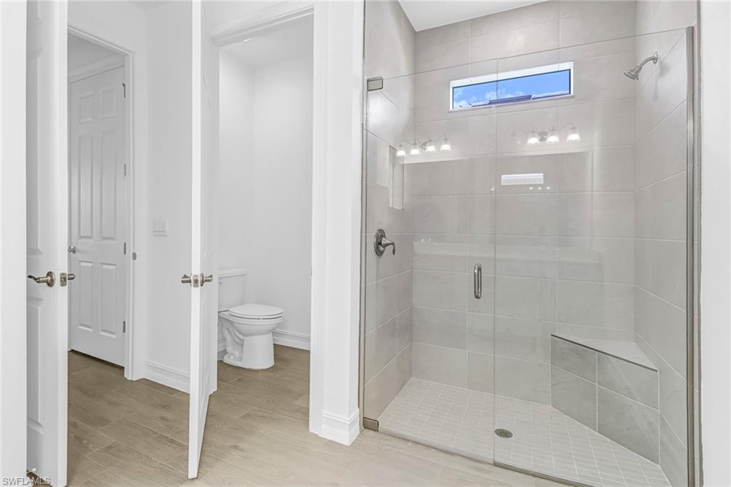 317 Spiaggio Court Naples, FL 34114 - Photo 15 of 46 a bathroom with a glass shower door