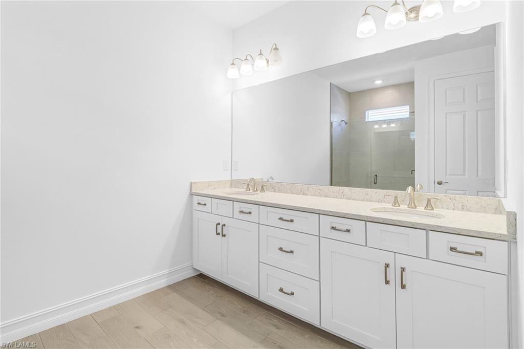 317 Spiaggio Court Naples, FL 34114 - Photo 16 of 46 a bathroom with a granite countertop sink and a mirror