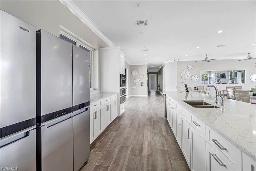 317 Spiaggio Court Naples, FL 34114 - Photo 40 of 46 a view of a kitchen with kitchen island wooden floors appliances