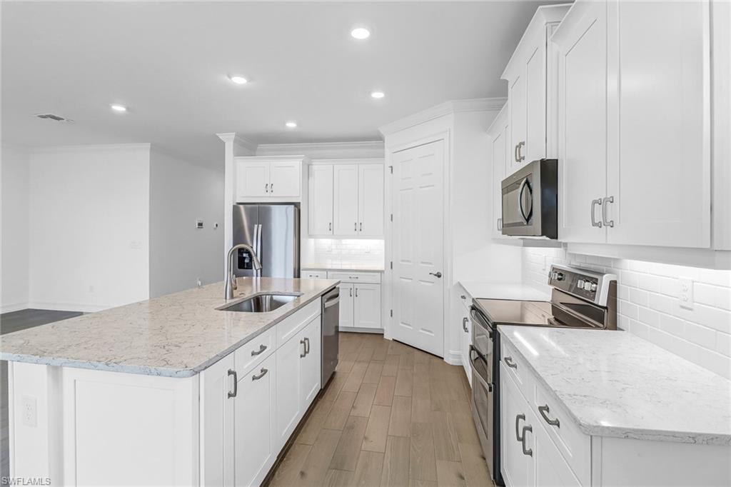 317 Spiaggio Court Naples, FL 34114 - Photo 4 of 46 a kitchen with a sink stove and cabinets
