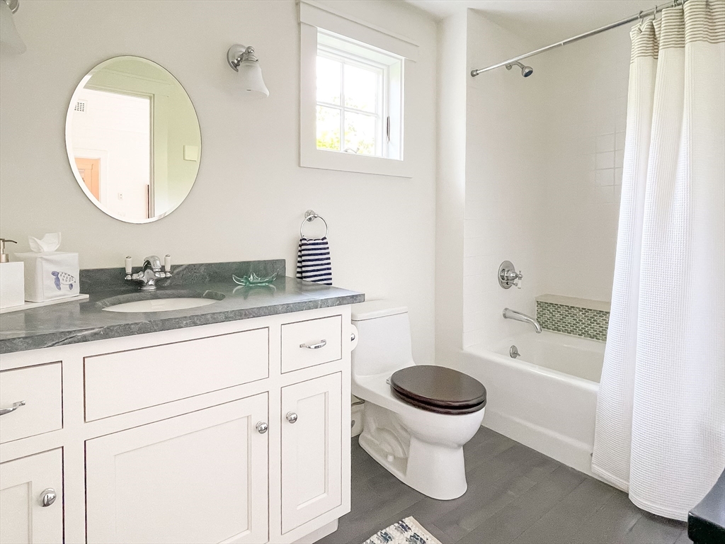 149 Litchfield Road Edgartown, MA 02539 - Photo 25 of 37 a bathroom with a granite countertop toilet sink and mirror