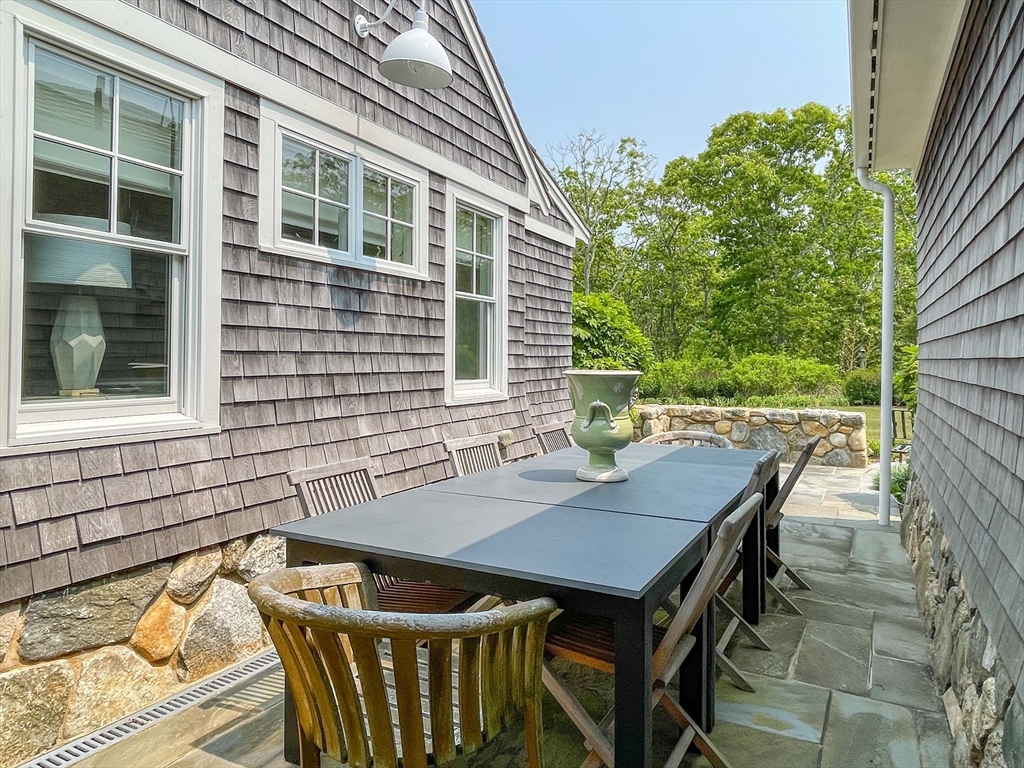 149 Litchfield Road Edgartown, MA 02539 - Photo 29 of 37 a view of a patio with table and chairs with wooden floor and fence