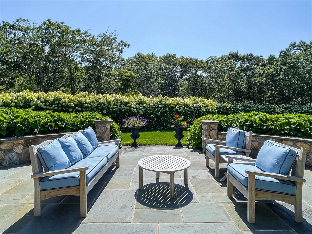 149 Litchfield Road Edgartown, MA 02539 - Photo 8 of 37 a view of a patio with couches table and chairs with plants and trees