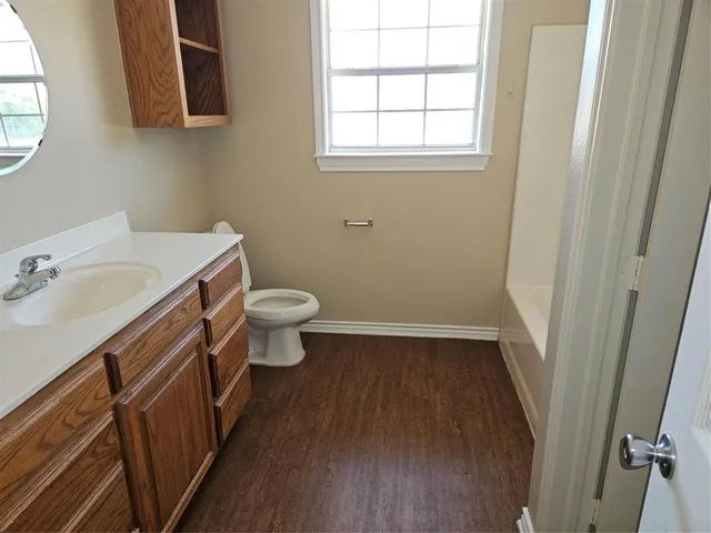 a bathroom with a sink a toilet and a window