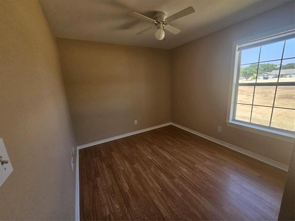 1605 Stuart Road Denton, TX 76209 - Photo 10 of 22 an empty room with wooden floor fan and windows