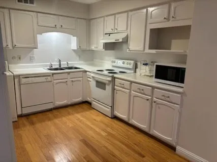 a kitchen with white cabinets appliances and a sink